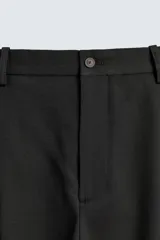 Pantalón straight fit color negro confeccionado en tejido con lana, con detalle de pliegues en el delantero, bolsillos frontales y traseros, y cierre frontal con cremallera y botón.