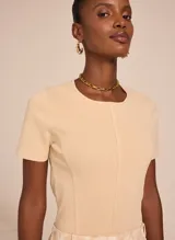 Remera color beige de tejido de punto acanalado, con cuello redondo y mangas cortas.