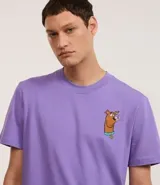 Remera de algodón color lila, corte comfort, cuello redondo y manga corta. Presenta un pequeño estampado bordado del personaje Scooby-Doo en el pecho izquierdo.