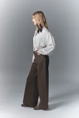 Jean de corte oxford y tiro alto, con pierna ancha desde la cadera hasta el ruedo. Confeccionado en denim rígido de color marrón, con cierre y botón frontal.