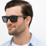 Lentes de sol INVU modelo IB22463A, con montura negra rectangular de acetato y lentes polarizadas grises.