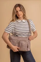 Bandolera de tafeta impermeable color beige, con dos bolsillos frontales con cierre y correa regulable. Diseño práctico y liviano ideal para uso diario.