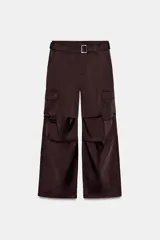 Pantalón cargo de tiro medio confeccionado en tejido satinado color beige, de corte recto y holgado. Cuenta con bolsillos laterales con solapa, bolsillos frontales y un cinturón integrado del mismo tejido con hebilla metálica.