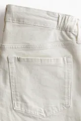 Jean tobillero de corte wide leg, color blanco, con diseño de tiro bajo y cinco bolsillos.