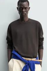 Jersey de punto de corte regular, confeccionado en una mezcla de algodón y lino. Presenta cuello redondo, manga larga y acabados en rib en cuello, puños y bajo.