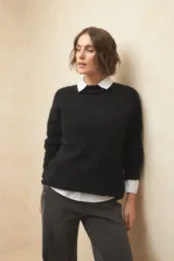 Polera beige de tejido de punto con cuello alto y mangas largas.