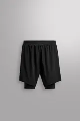 Short de running negro de tejido técnico perforado, ligero y elástico, con malla interior. Presenta cintura elástica ajustable con cordón interior, bolsillo trasero con cierre de seguridad y bajo con aberturas laterales.