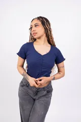 Remera de morley negra, entallada, con cuello en V y cierre frontal con botones. Presenta mangas cortas con terminación ondulada.