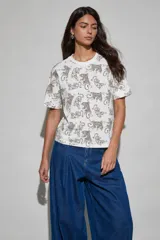 Remera blanca de manga corta y cuello redondo con estampado integral de tigres en color marrón.