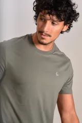 Remera de manga corta con cuello redondo, confeccionada en tejido de punto liso color verde militar. Presenta el logo de la marca Original Penguin bordado en pequeño en el pecho.