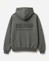 Canguro oversize de felpa pesada color gris oscuro, con capucha doble y bordado premium en la espalda con la frase 'OBSESSION The process made me.' y el número de edición en la manga.
