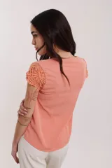 Blusa color salmón con escote en V y mangas cortas con detalle de encaje floral.