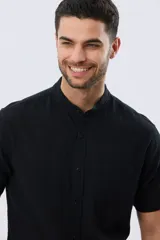 Camisa de lino y algodón de manga corta, color negro, con cuello mao, cierre frontal con botones y bolsillo ojal en el pecho.