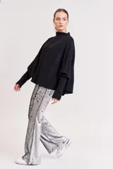 Pantalón de lentejuelas plateadas, corte acampanado.