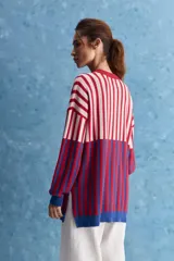 Sweater de tejido jacquard con diseño de rayas verticales en tonos rojo, blanco y azul. Presenta cuello redondo, hombros caídos y puños en contraste de color azul.