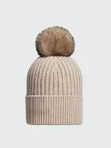 Gorro tipo beanie de punto acanalado en color beige, confeccionado en cachemir, con detalle de pompón superior y logo de la marca aplicado en el frente.