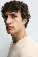 Camiseta relaxed fit color marrón, confeccionada en tejido con estructura, cuello redondo y manga corta.