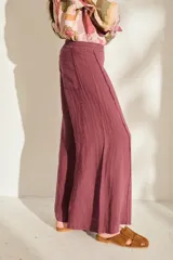 Pantalón ancho negro de lino con cintura elástica y detalles de flecos en los laterales.
