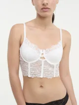 Bustier de encaje blanco con diseño de copas con aro y estructura tipo corset. Presenta breteles finos regulables y un detalle de abertura en el centro del escote.