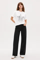 Remera de algodón blanca de manga corta y cuello redondo, con estampa frontal de una estrella plateada adornada con lentejuelas y efecto de flecos brillantes.