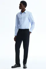 Camisa celeste de corte slim fit, con cuello inglés y cierre frontal de botones.