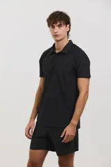 Chomba deportiva de manga corta, color negro, con cuello polo y cierre frontal de tres botones. Confeccionada en tejido técnico ultra liviano, fresco y respirable con alta elasticidad.