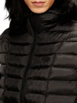 Chaleco acolchado negro con capucha, cierre frontal y diseño híbrido que combina paneles de nylon con mangas de tejido tipo buzo con detalles de líneas blancas.