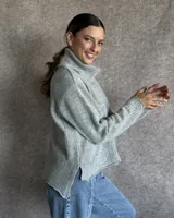 Sweater color crudo de cuello alto con mangas largas y corte holgado.