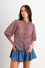 Camisa de algodón bordado color violeta, con cuello mao, mangas 3/4 abullonadas y cierre frontal con nudos y presillas de estilo oriental.