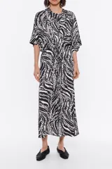 Vestido midi de viscosa con estampado abstracto en blanco y negro, escote en pico con lazo y manga corta.