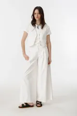 Chaleco color crudo de canvas de algodón, con corte sastrero masculino, escote en V y botones de nácar.