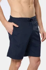 Bermuda de baño verde militar lisa, con bolsillos laterales y etiqueta con logo en la pierna.