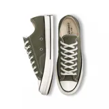 Championes Converse Chuck 70 de caña baja, color verde oliva, con cordones blancos y suela de goma blanca con línea negra.