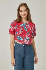 Blusa roja con estampado de flores y hojas en tonos celeste, blanco y rosa.