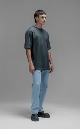 Remera de corte relajado y silueta amplia, con hombros caídos y mangas cortas. Confeccionada en algodón premium, presenta un diseño liso en color gris oscuro.