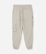 Pantalón jogger de poliamida color beige, de corte holgado con cintura elástica ajustable mediante cordón, puños elásticos en los tobillos y cuatro bolsillos cargo laterales con solapa.
