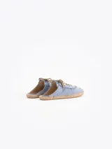 Slide estilo alpargata confeccionado en cuero descarne color celeste, con cordones beige, detalles de flecos y dijes colgantes, sobre una base de yute trenzado.