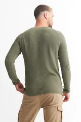 Sweater azul de punto con cuello redondo y mangas raglán.