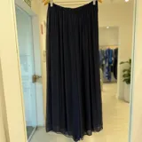 Pantalon ancho color azul marino, de tiro alto con cintura elastizada y confeccionado en tejido ligero y fluido con transparencias.