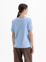 Remera de algodón con cuello redondo y mangas cortas. Presenta un diseño estampado y bordado de flores y un corazón en el frente.