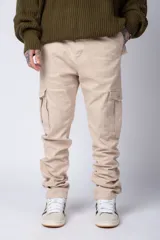 Pantalón cargo color beige, con bolsillos laterales tipo cargo con solapa y cierre de botón, corte recto y ajuste cómodo.