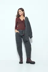 Top de manga larga color negro con escote en V y detalle de frunce central. Presenta un corte entallado que se adapta a la figura.