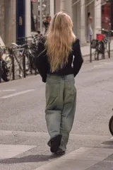 Jeans de tiro medio y corte ancho, confeccionados en denim con lavado estilo vintage de efecto desgastado. Presentan diseño de doble cinturilla superpuesta, cinco bolsillos tradicionales, trabillas para cinto y cierre frontal con cremallera y botón metálico.