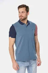 Remera polo de piqué azul con cuello azul marino y mangas en azul marino y rosa.