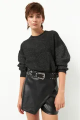 Sweater negro tramado de manga larga y cuello redondo.