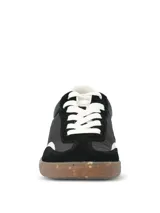 Championes urbanos de diseño deportivo en color negro, con paneles de gamuza sintética y material textil. Presentan detalles en blanco en el talón, cordones y borde frontal, con suela de goma tipo caramelo con efecto moteado.