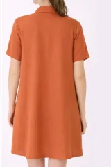 Camisa maternal de viscosa suave y liviana, con estampado de rayas verticales amarillas y blancas. Presenta cuello camisero, mangas cortas y bolsillos prácticos.