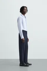 Camisa de corte regular fit en color celeste, con cuello italiano, manga larga con puños abotonados y cierre frontal de botones.