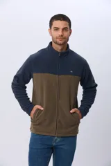 Campera polar bicolor de diseño texturado suave al tacto, con cuello alto, cierre frontal completo y bolsillos laterales. Presenta una combinación de color azul marino en la parte superior y marrón en la inferior, con un pequeño logo bordado en el pecho.