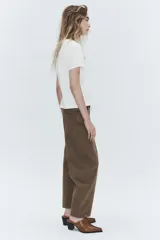 Jeans de tiro medio con corte cropped y diseño de costuras torcidas. Presenta trabillas en la cintura, cinco bolsillos clásicos y cierre frontal con cremallera y botón metálico.